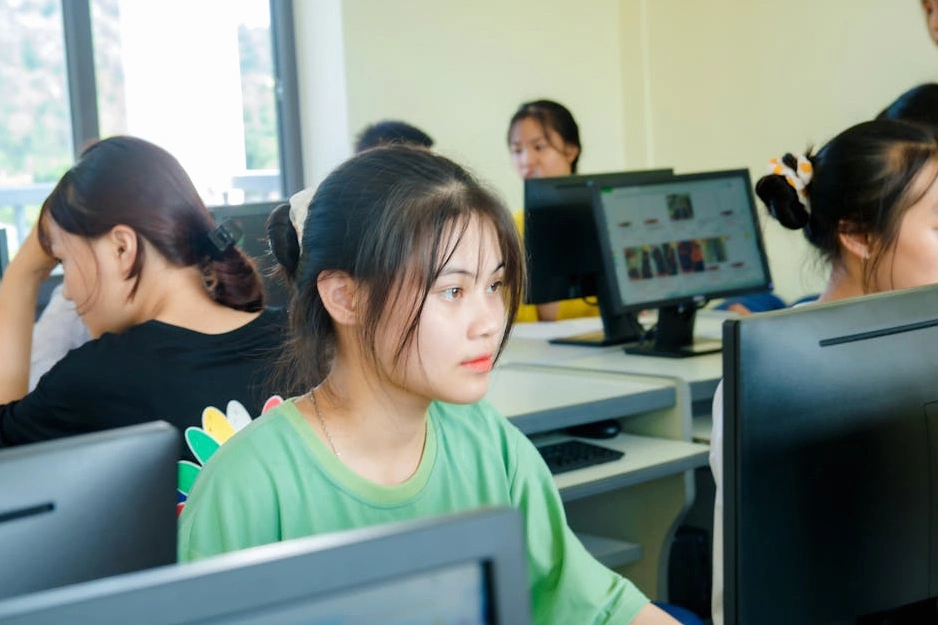 Studente sorridente che utilizza un laptop in un ambiente di apprendimento moderno